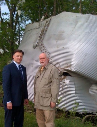 ISBA President John G. Locallo (left) views tornado damage with Shawneetown lawyer James Smith, who lives near Harrisburg. The grain bin came from a nearby farm and was embedded in a grove of trees.