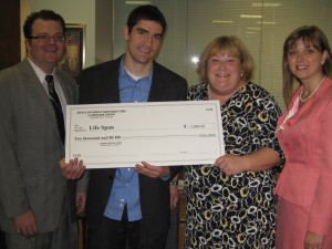 Robert Fink (left), YLD vice chair and Kelly Gandurski (right), YLD chair, present the $2,000 check to Ari Bernstein and Sandra Blake of Life Span.
